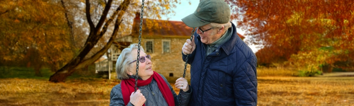 Older Adult Couple on a swing looking at each other talking