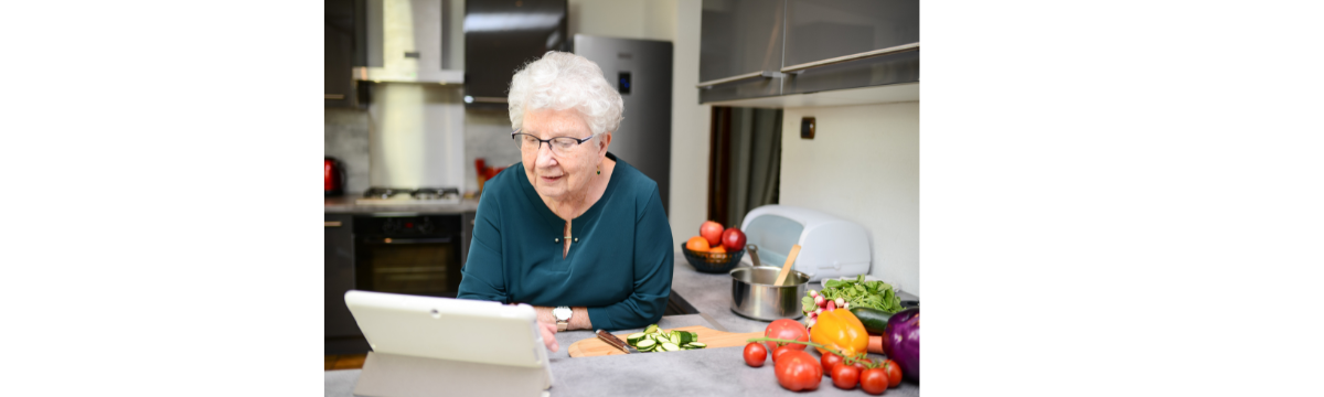 Older Adult woman looks at a tablet reading a recipe