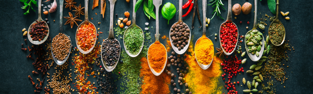 row of spoons with different spices in them