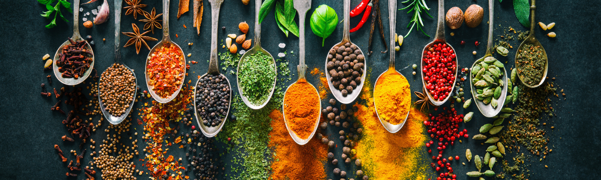 row of spoons with different spices in them