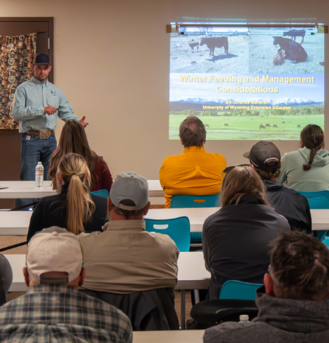 A presenter speaks to attendees during a session on winter feeding and cattle management considerations.