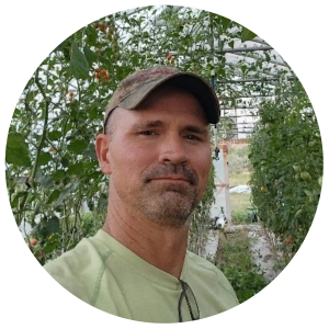 Evan Van Order, Founder of Living Root Farm in Helena, MT, Standing in Living Root's Produce Greenhouse - Profile Image
