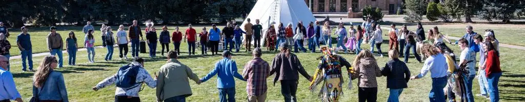 circle of people holding hands at Native American event