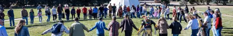 circle of people holding hands at Native American event