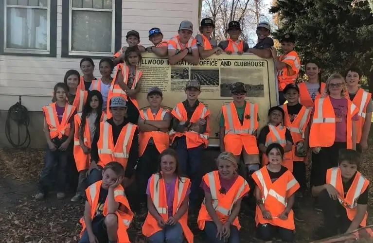 4-h club after highway cleanup posing by willwood clubhouse sign