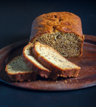 3 slices and a loaf of banana bread on a rusty-looking round platter 