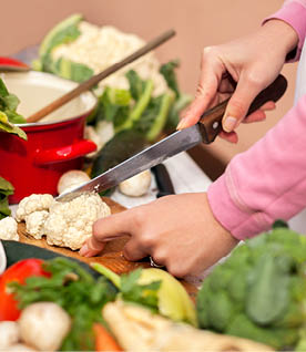 Female hands shown chopping cauliflower