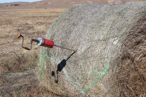 photo of hay corer in a large round hay bale
