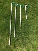 4 PVC pipes of different lengths drying in the sun on green grass 