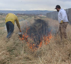 Two people burning a ditch 