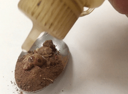 Liquid drop on soil in a spoon 