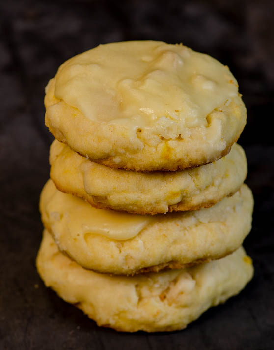 A stack of four orange macadamia nut cookies. 