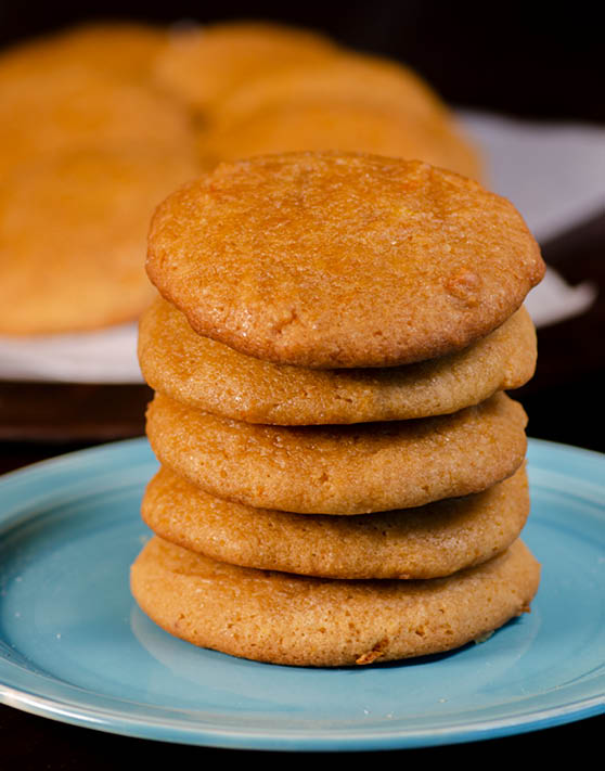 A stack of five soft orange cookies on a small blue plate. 