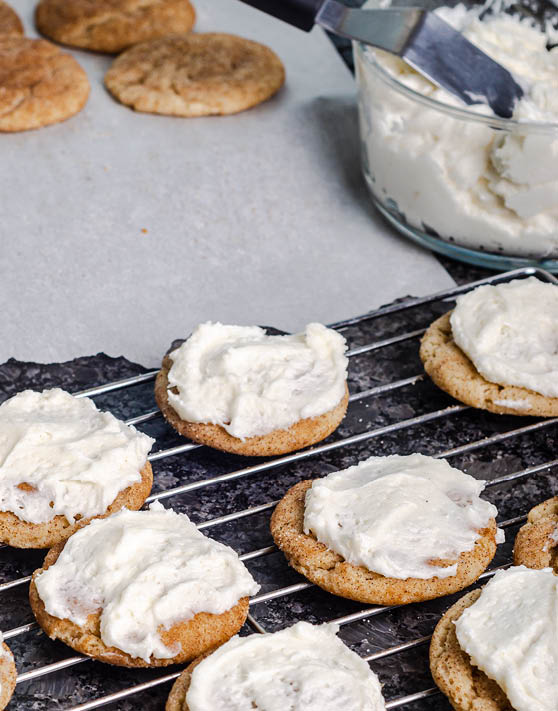 Rows of frosted chai spice snickerdoodles placed on a cooling rack.
