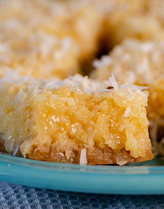 A close up of coconut bars placed on a blue plate. 