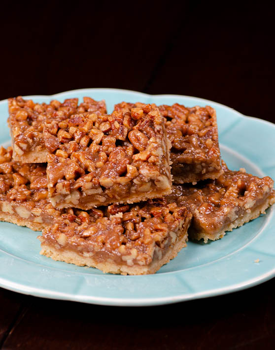 Five pecan pie shortbread bars placed on a blue plate. 