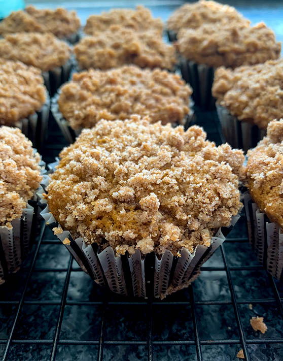 Columns of pumpkin spice streusel mufffins on a cooling rack. 