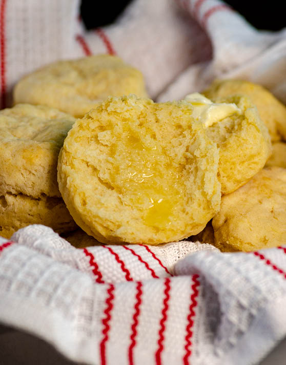 Baking powder cloud biscuits with butter placed in a red and white dish towel. 