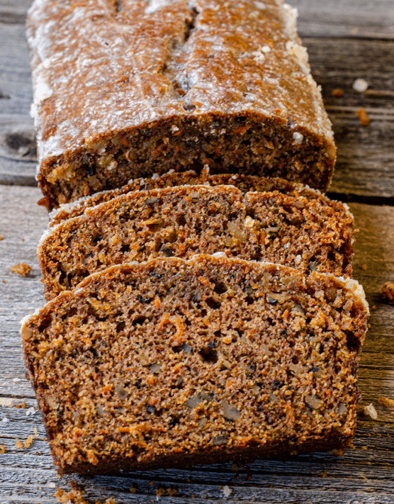 A loaf of pineapple carrot bread with two sliced pieces. 