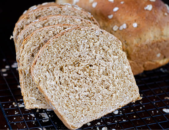 Sliced molasses oatmeal bread placed on a cooling rack. 