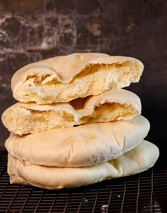 Stacked white pita bread placed on a cooling rack. 