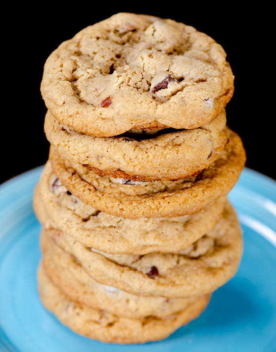 Chocolate chip cookie stacked on top of eachother on a blue plate. 