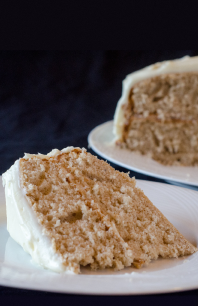 Two-layer spice cake with white frosting on a white plate 