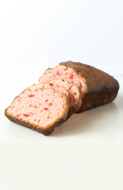 Light pink cherry bread slices and loaf on a white tabletop 