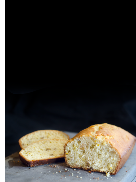 Slices and loaf of lemon bread on a silver pan 