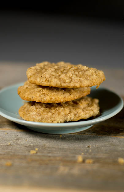 3 oatmeal cookies stacked on a small blue plate  The plate is on a reclaimed wood table 
