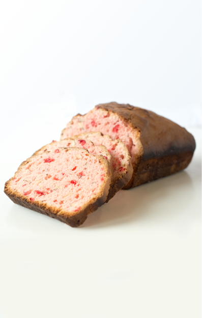 Light pink cherry bread slices and loaf on a white tabletop 