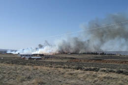 Farmland with heavy smoke in the background 