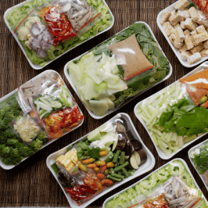 Prepackaged trays of vegetables: An assortment of pre-packaged trays with fresh vegetables, showcasing food packaging and portioning for convenience.