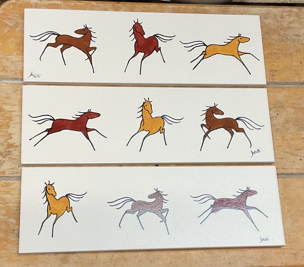 Three horizontal ceramic tiles featuring minimalist horse illustrations in earthy tones, each horse in a different dynamic pose, drawn in a stylized, folk-art-inspired manner.