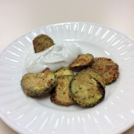 zucchini chips on white plate with cottage cheese dip