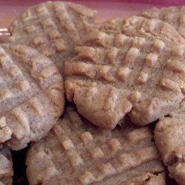 a pile of baked cookies with fork imprints