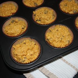unbaked muffins in papers in a metal muffin pan