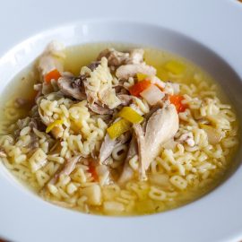white bowl with chicken soup and alphabet noodles