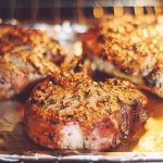 3 pork chops on baking sheet in oven