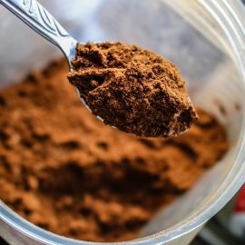 spoonful of cocoa powder out of plastic container