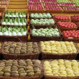 baskets of potatoes, carrots, and varied fruits