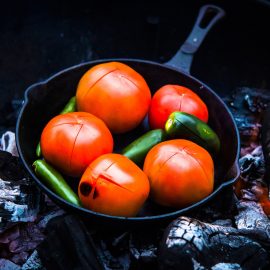 chili peppers and tomatoes in iron cast skillet