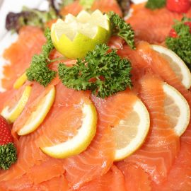 sliced salmon garnished with lemons and parsley