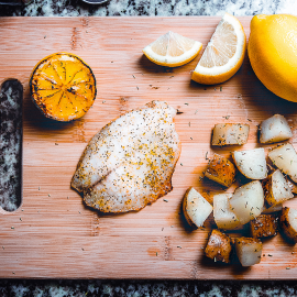 fish, potatoes, and lemon on cutting board