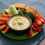 Dip in bowl surrounded by vegetable sticks and crackers