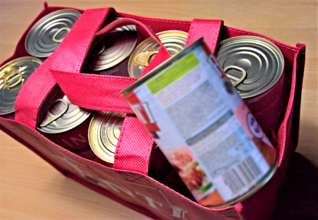 cans of food in red grocery bag