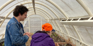 Two people working in a hoop house.