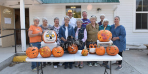 Ladies standing behind table with pumpkins