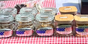 The national flag of the United States and the flag of the United States Marine Corps are proudly displayed at the booth of Marine Corps veteran Douglas Bassford, who offers homemade canned and pickled vegetables at venues in Lander and Riverton.