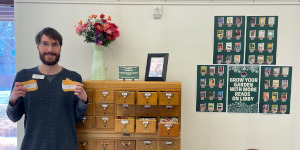 Man displaying seeds in a library.